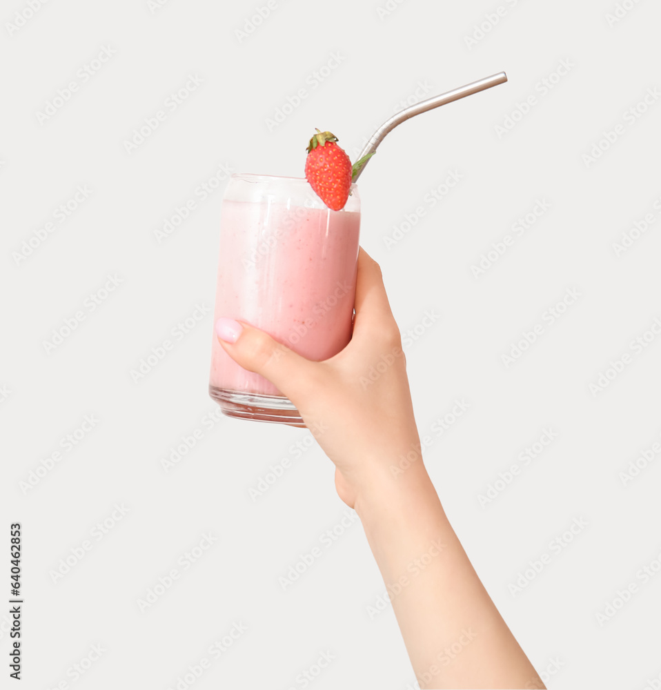 Woman holding glass of tasty strawberry smoothie on white background