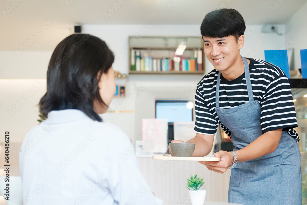 Waiter serving a cup of coffee to customer.