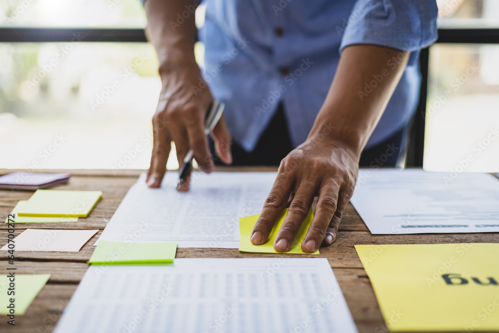 Man working on paperwork on desk, planning marketing business in office.