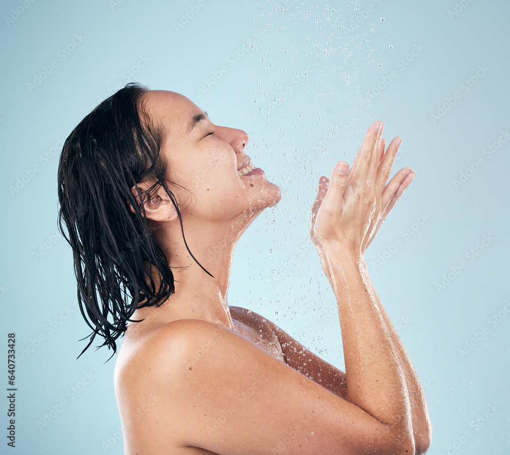 Skincare, shower and woman smile cleaning in studio isolated on a blue background. Water splash, hyg