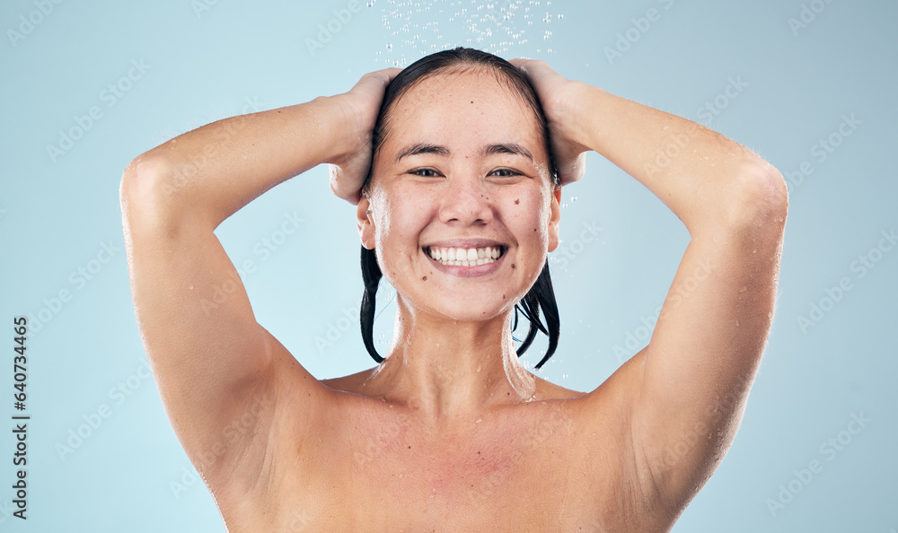 Face, shower and happy woman washing hair in studio isolated on blue background. Water splash, hygie