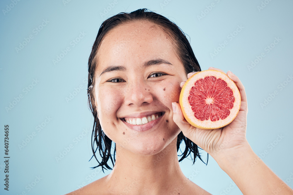 Portrait, smile or happy woman with grapefruit for skincare or beauty in studio on blue background. 