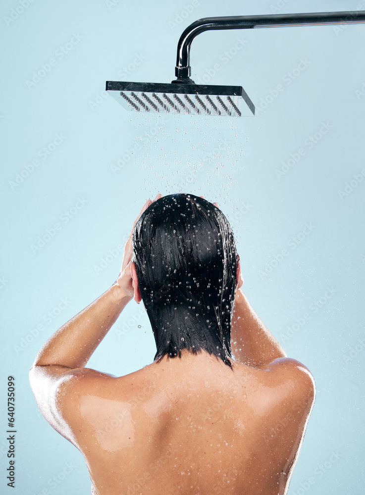 Woman, shower and back in water drops for hygiene, grooming or washing against a blue studio backgro