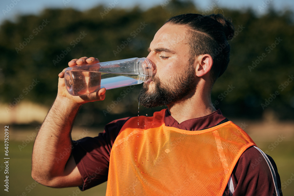 Sports, drinking water and man in field to rest after training, workout and exercise outdoors. Fitne