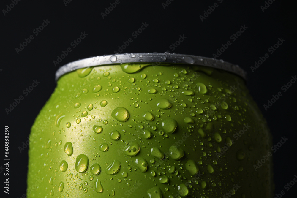 Green can of fresh soda with water drops on dark background, closeup