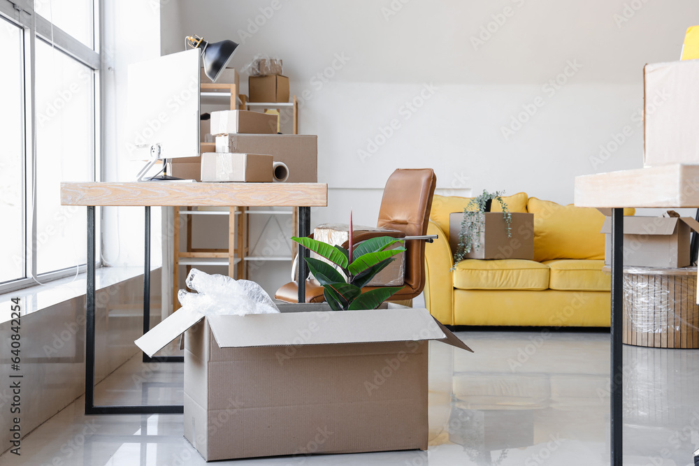 Interior of office with cardboard boxes on moving day