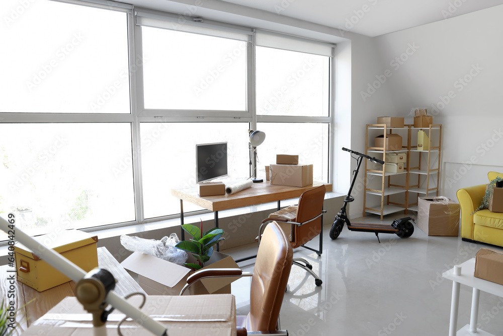 Interior of office with cardboard boxes on moving day