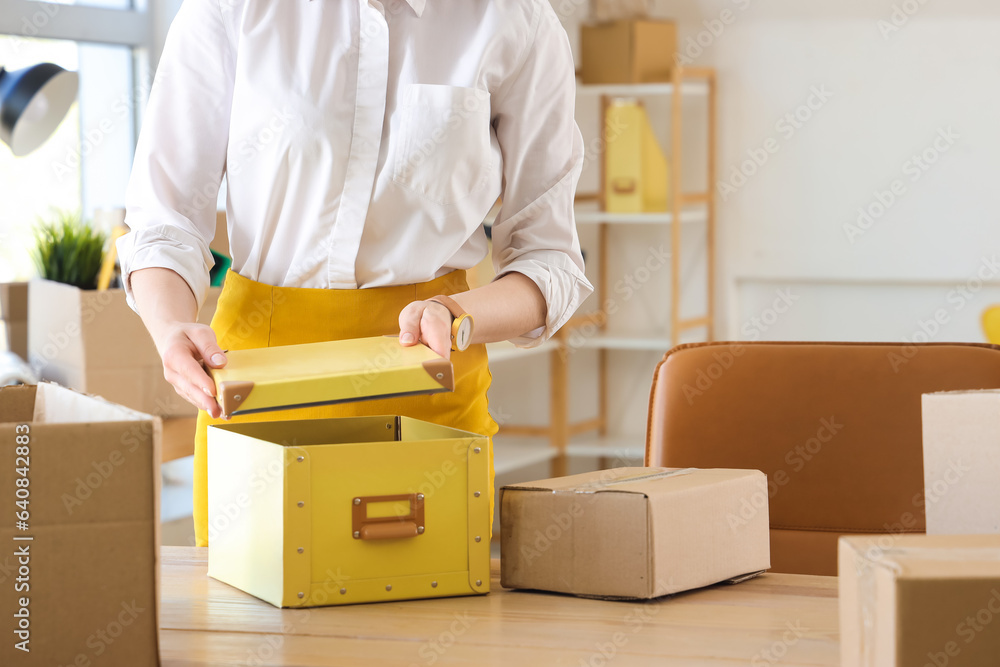 Businesswoman packing belongings into box on moving day