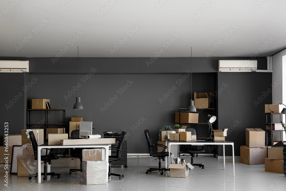 Interior of modern office with cardboard boxes on moving day