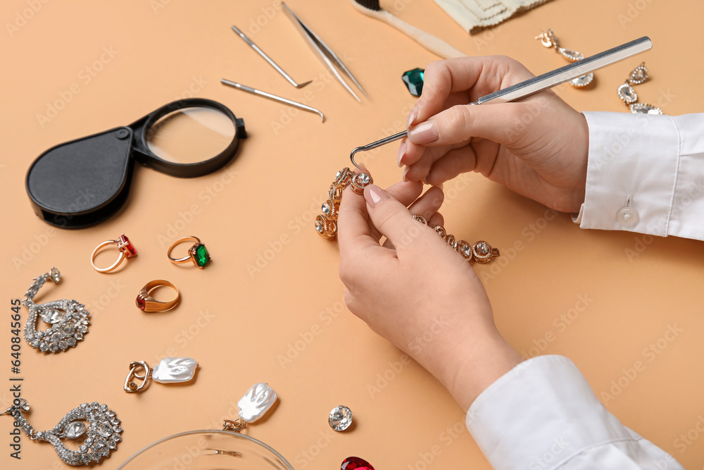 Woman cleaning beautiful accessories on color background, closeup