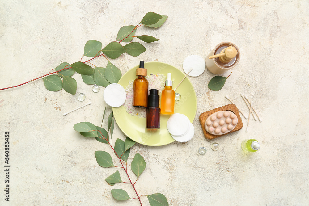 Composition with cosmetic products and eucalyptus branches on light background