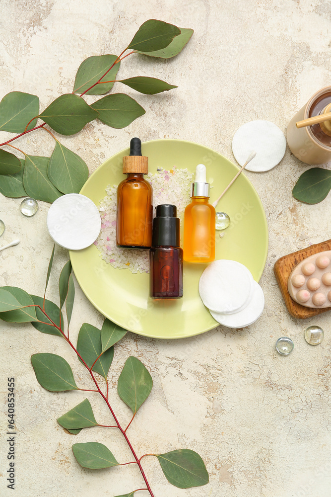 Composition with cosmetic products and eucalyptus branches on light background