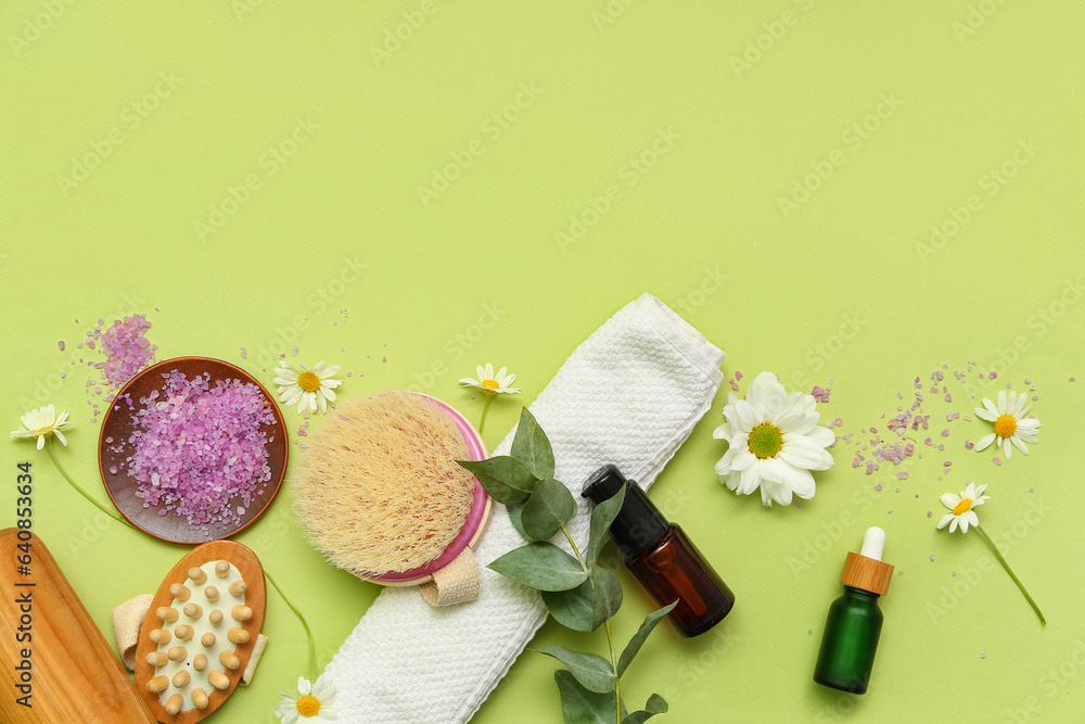 Composition with bath supplies, cosmetic products and flowers on green background