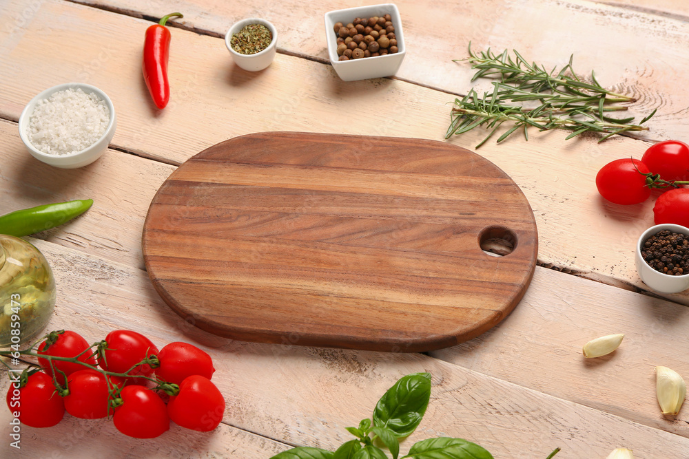 Composition with cutting board, spices and vegetables on light wooden background