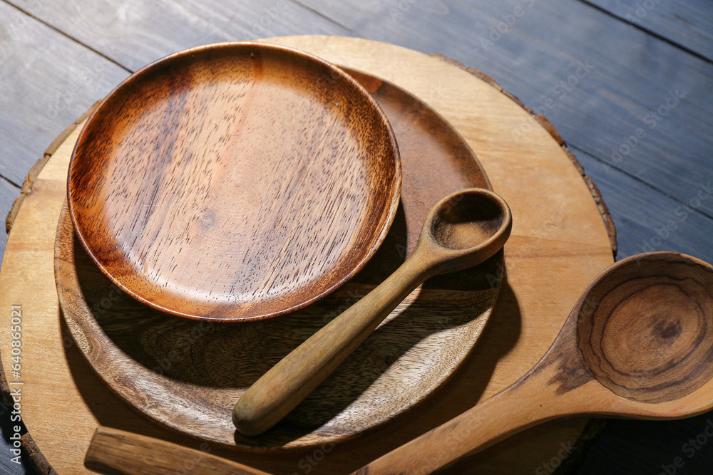 New cutting board, plates and spoons on blue wooden background