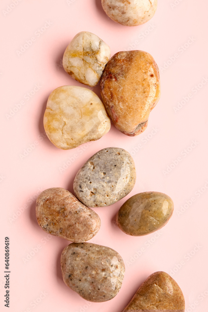 Many pebble stones on pink background