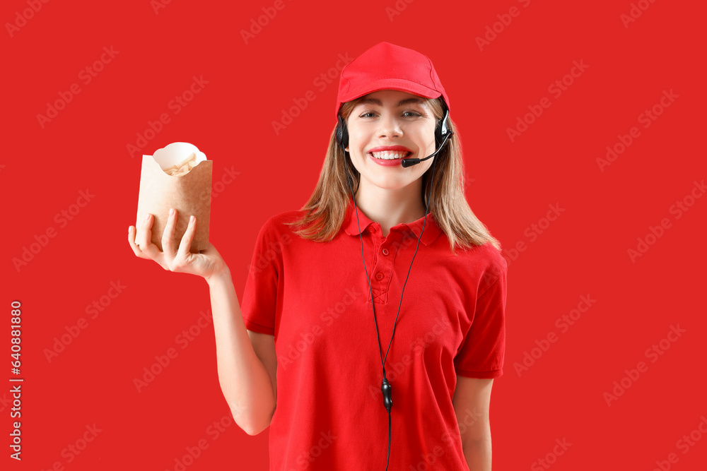 Female worker with pack of french fries on red background