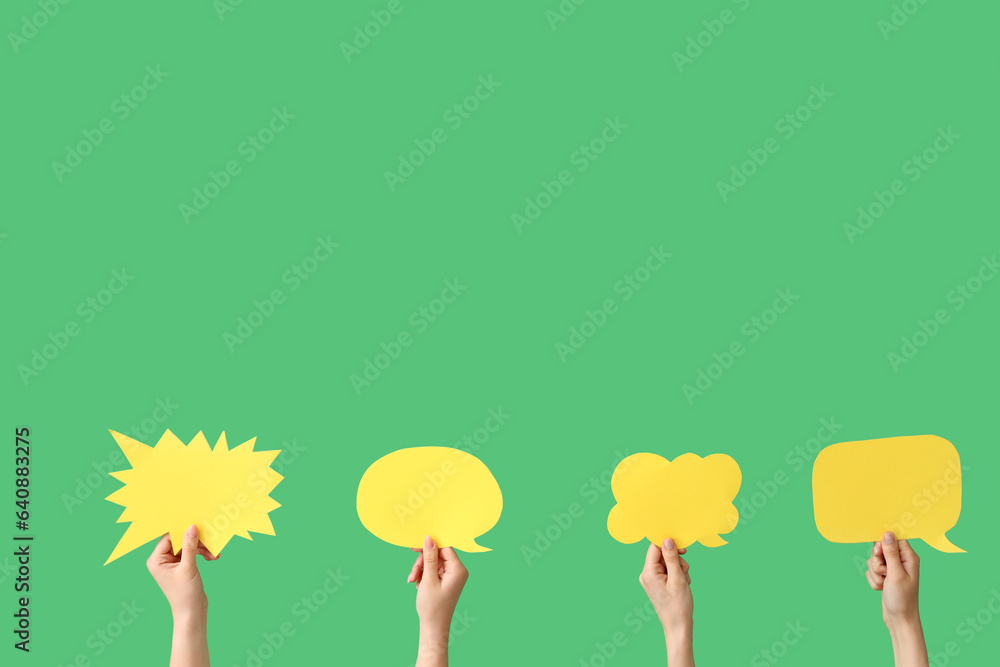 Female hands with speech bubbles on green background