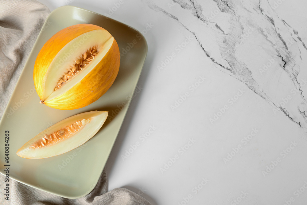 Plate with sweet melon on white background