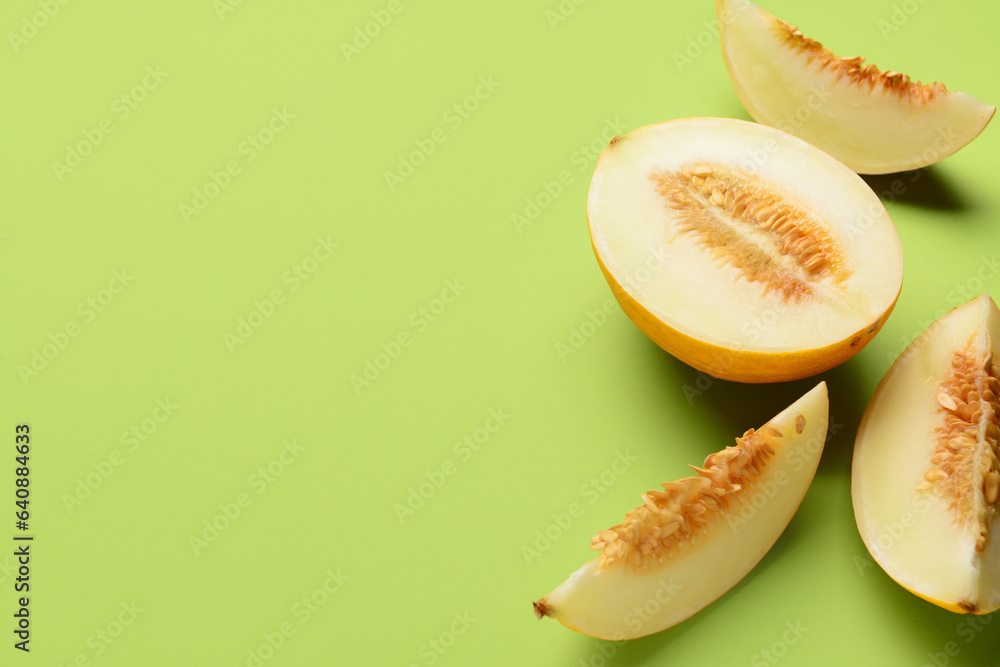 Pieces of sweet melon on green background