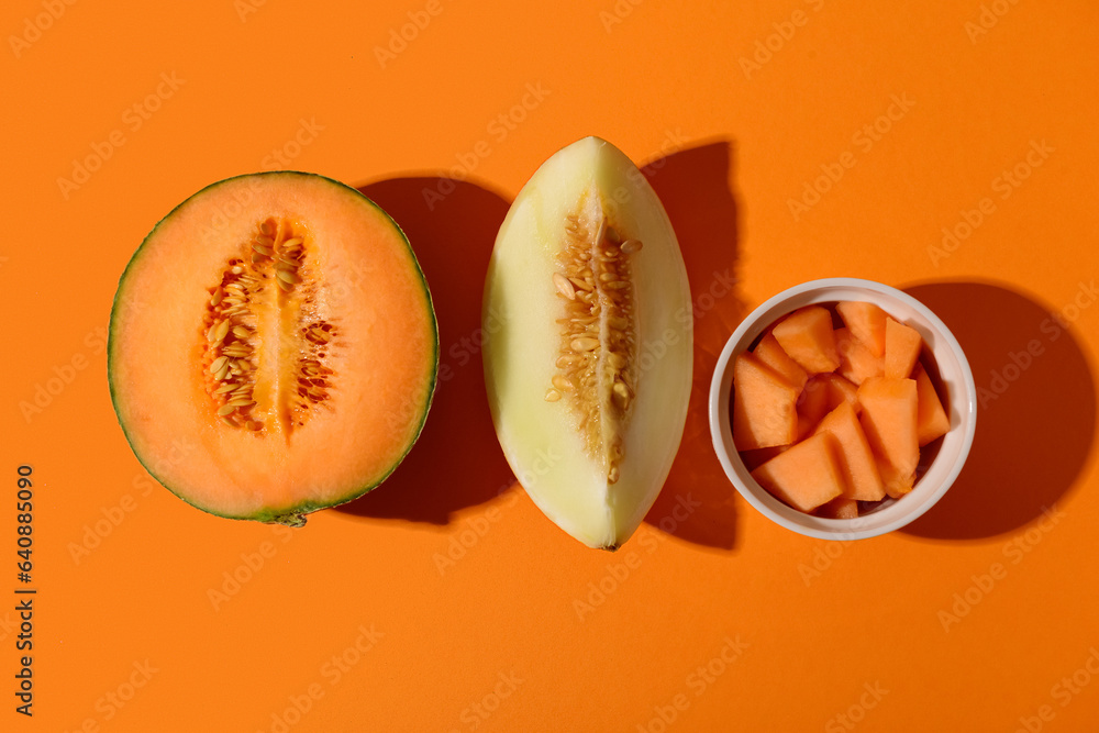 Sweet melons and bowl with pieces on orange background