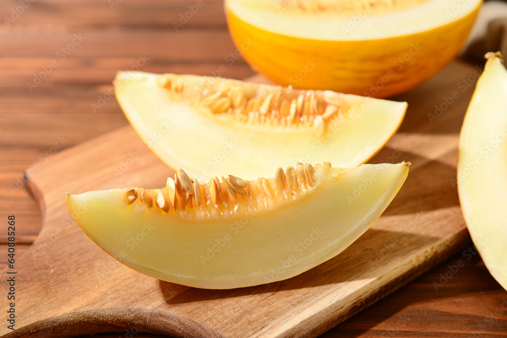 Board with pieces of sweet melon on wooden table