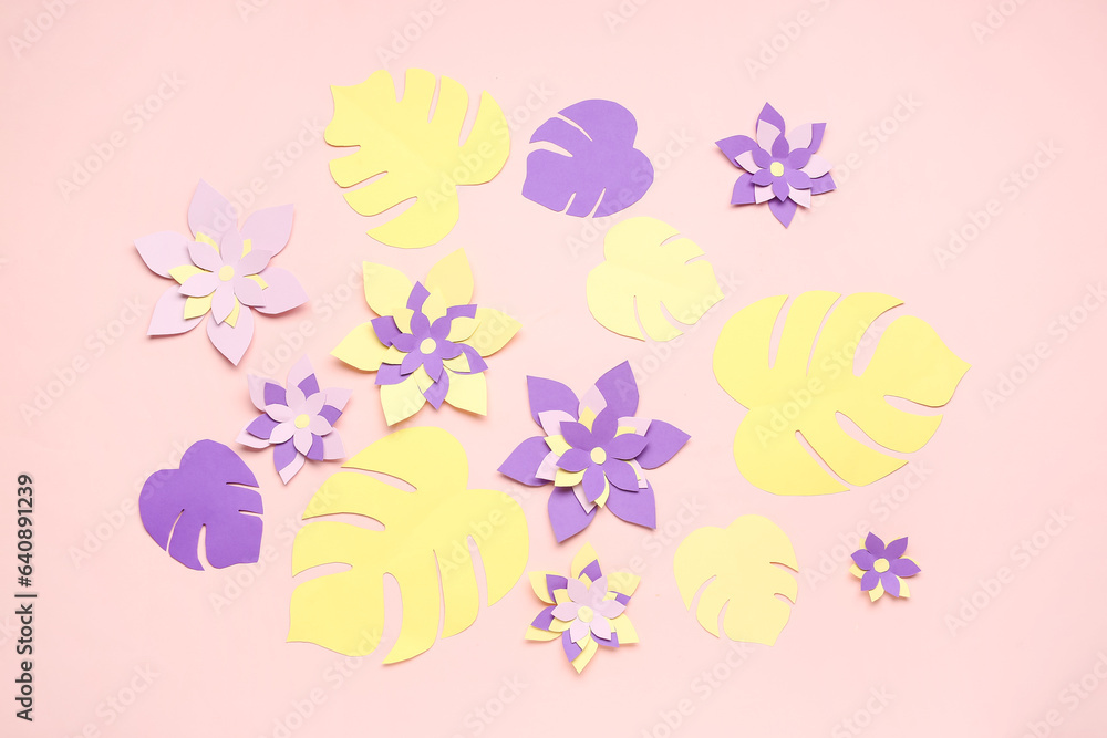 Colorful origami flowers with leaves on pink background