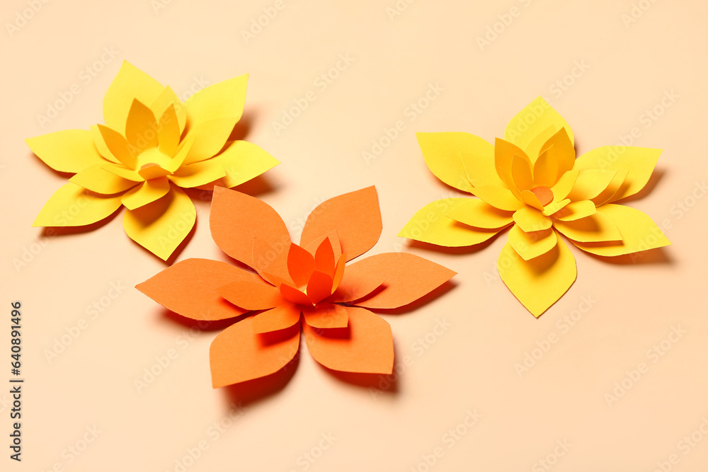 Colorful origami flowers on beige background