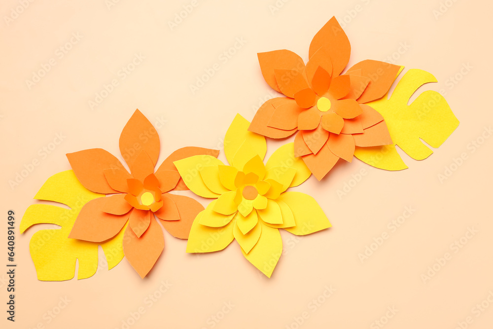 Colorful origami flowers with leaves on beige background