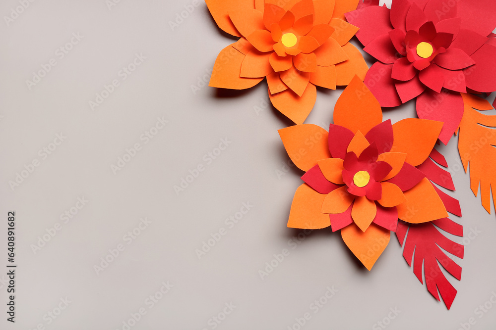 Colorful origami flowers with leaves on grey background