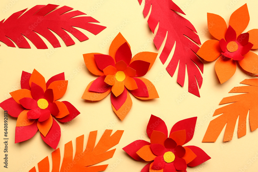 Colorful origami flowers with leaves on beige background