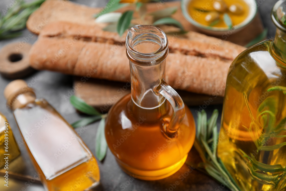 Jug and bottles of fresh olive oil on table