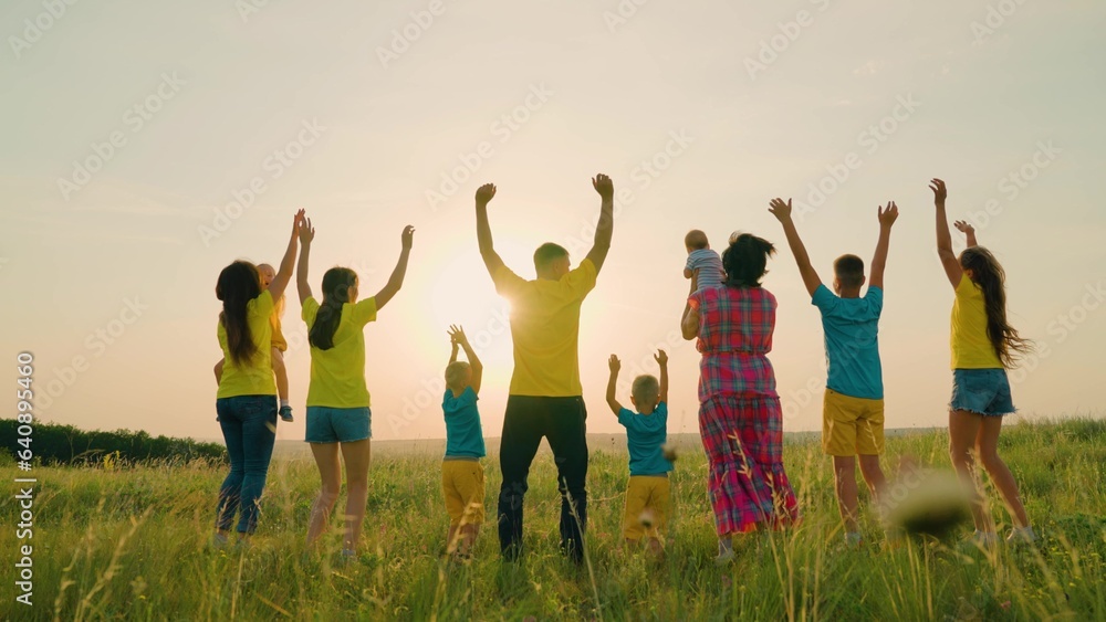 Dad mom with son daughter are walking, rejoicing, jumping raising their hands to sky. Happy big fami