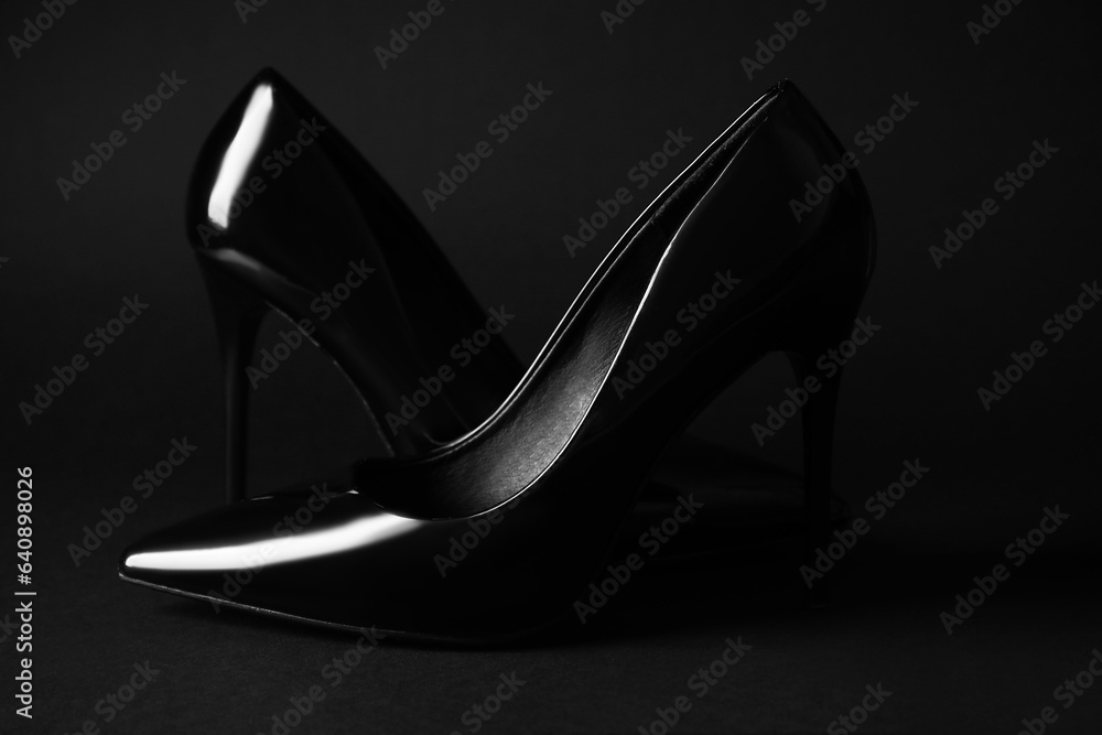 Stylish high heels on black background