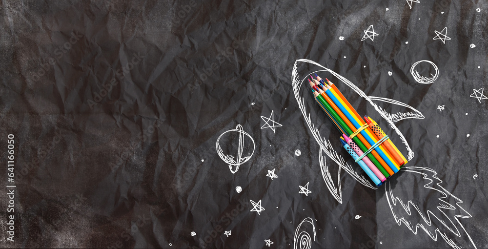 Back to school theme with hand drawn rocket and colored pencils - crumpled paper background