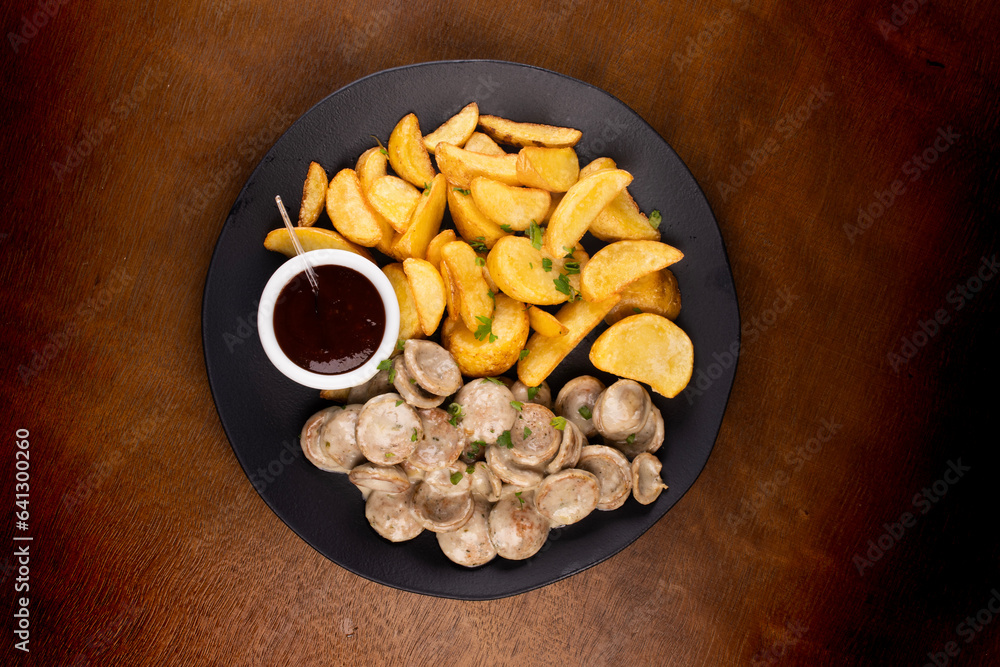 portion of finger food with bratwurst bratwurst fried sausages and potatoes and barbecue sauce top v