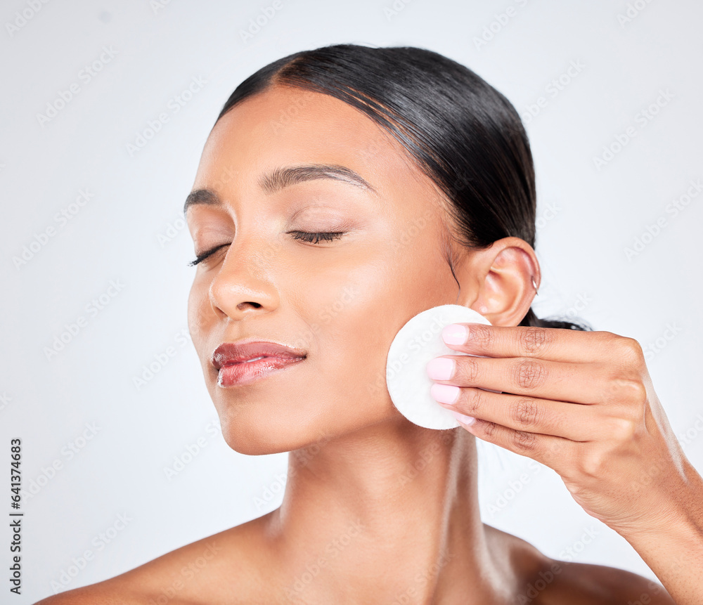 Skincare, beauty and woman with cotton pad on face for natural glow and cosmetics in studio. Dermato