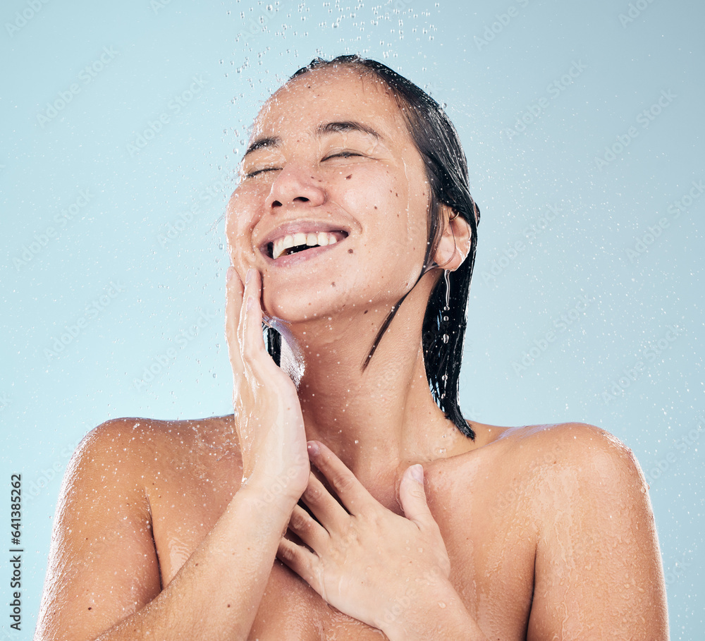 Skincare, shower and happy woman cleaning in studio isolated on a blue background. Water splash, hyg