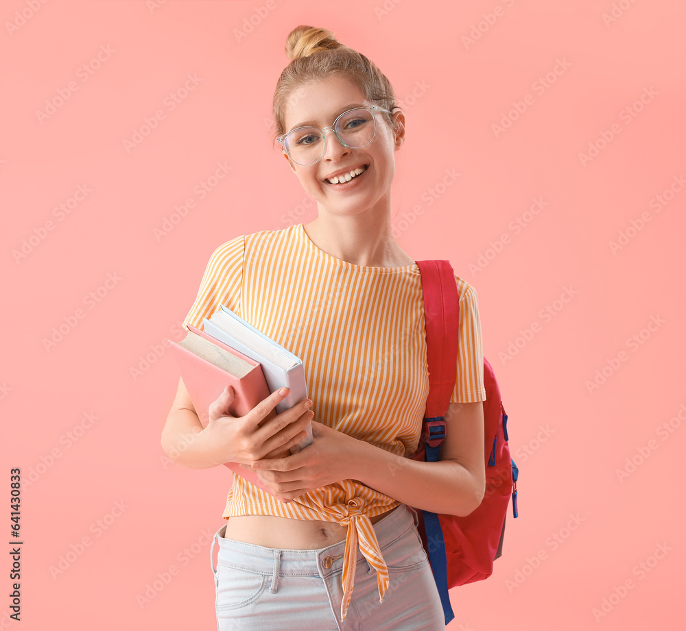 Female student with books and backpack on pink background