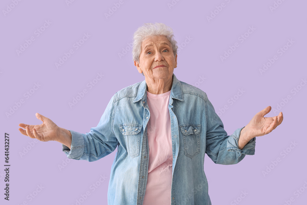 Confused senior woman on lilac background