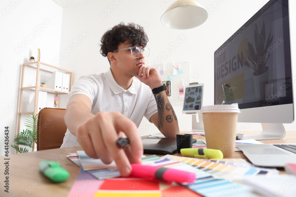 Male graphic designer working at table in office