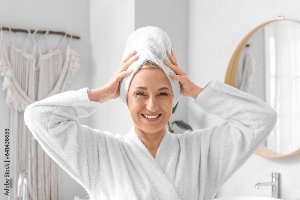 Mature woman with towel in bathroom