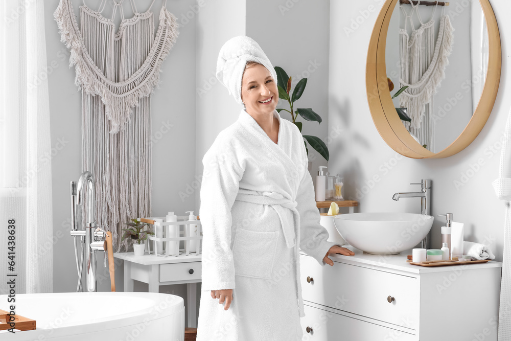 Mature woman with towel in bathroom