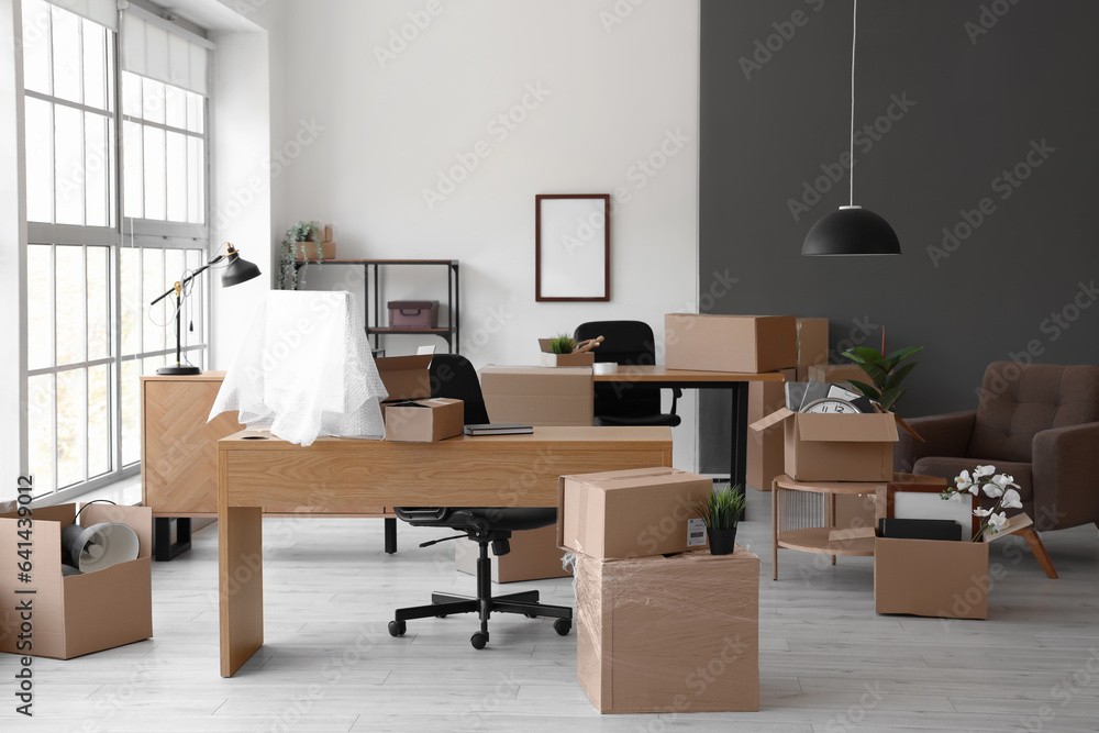 Interior of light office with cardboard boxes on moving day