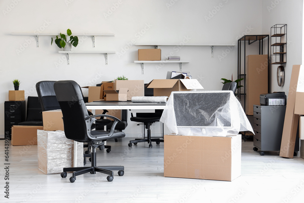 Interior of light office with cardboard boxes on moving day