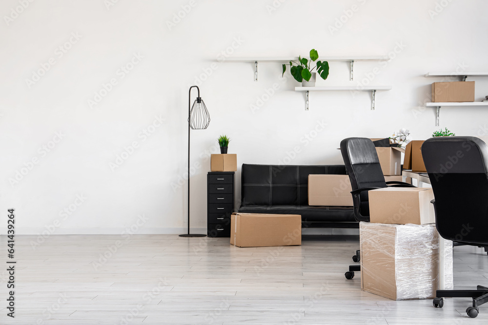 Interior of light office with cardboard boxes on moving day