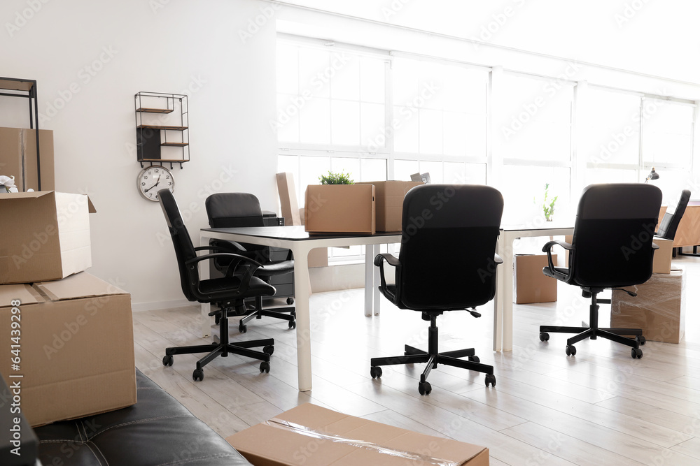 Interior of light office with cardboard boxes on moving day