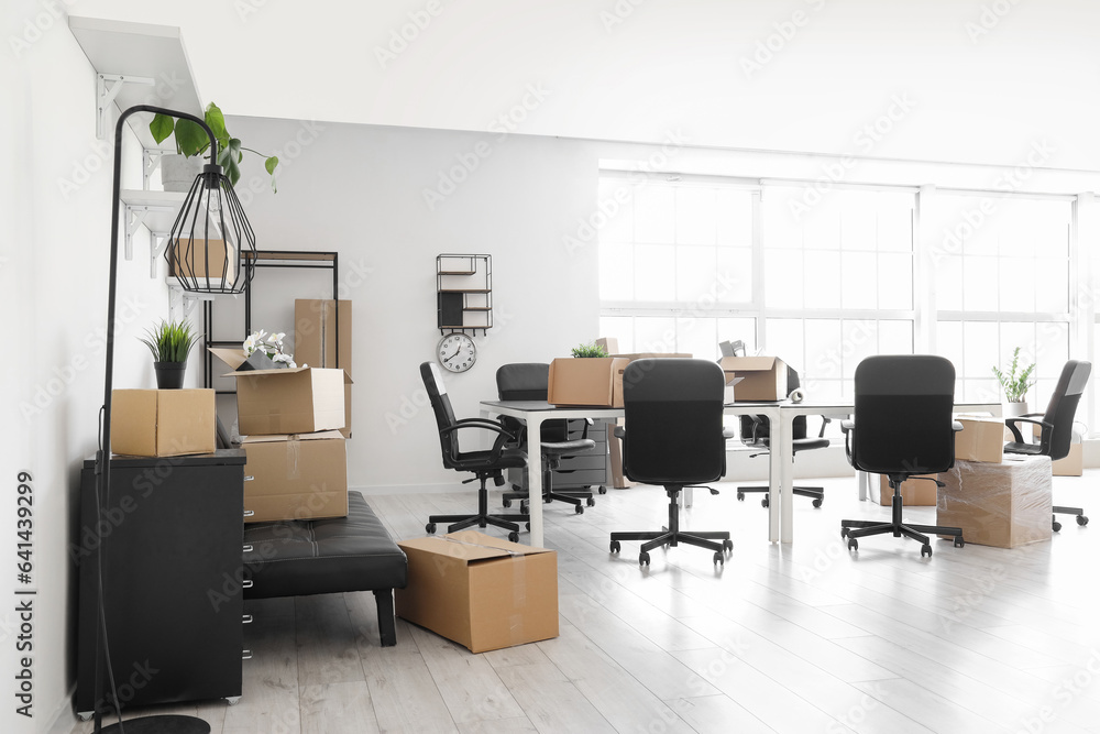 Interior of light office with cardboard boxes on moving day