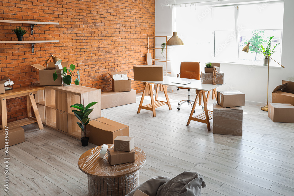 Interior of stylish office with cardboard boxes on moving day