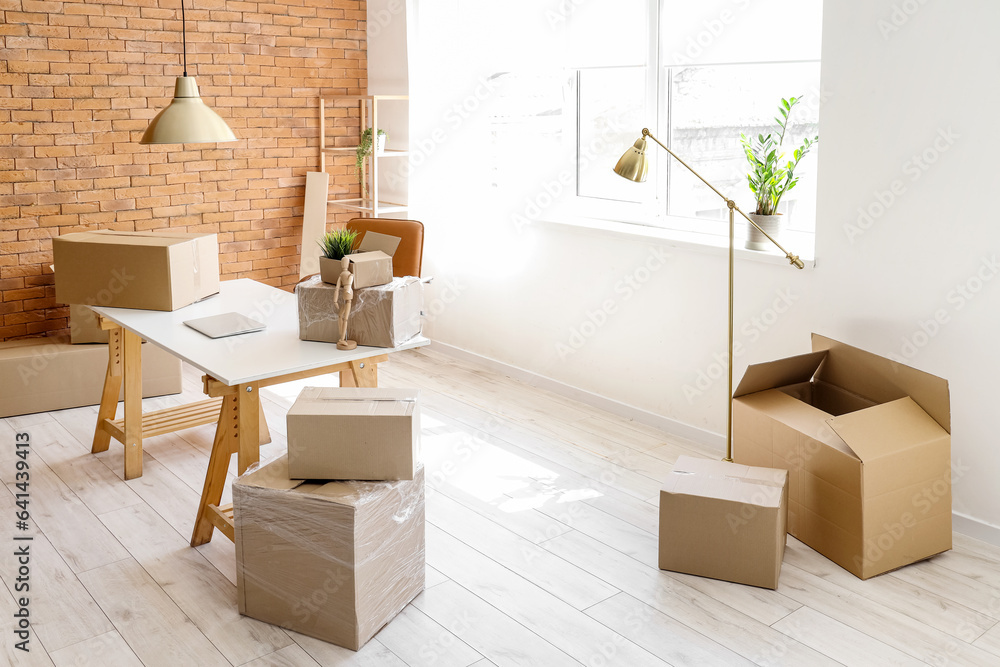 Interior of stylish office with cardboard boxes on moving day